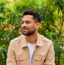 An image of Akshay Petta in a beige jacket and a white t-shirt